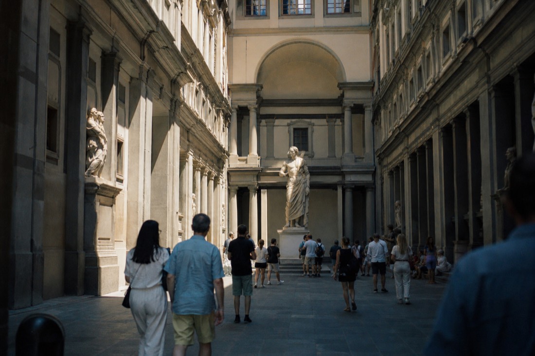 Statue of David seen down the long sculpture hall of the Accademia with soft skylight from above