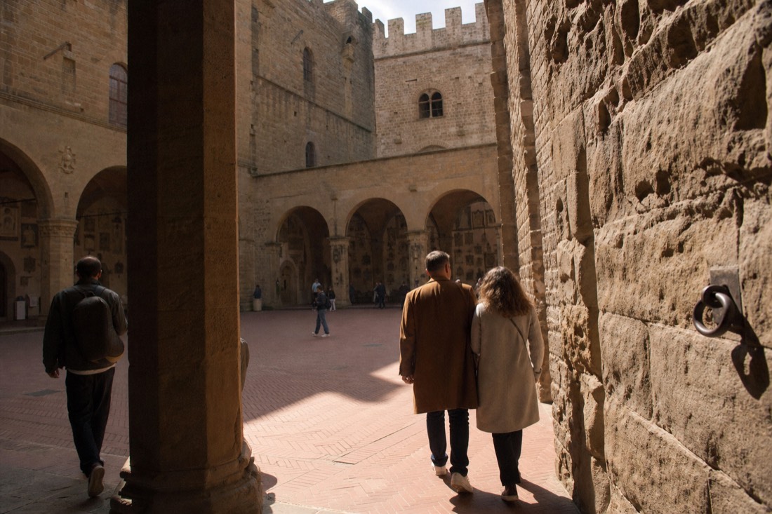 The stone courtyard and open loggia of the Bargello museum in Florence under soft morning light